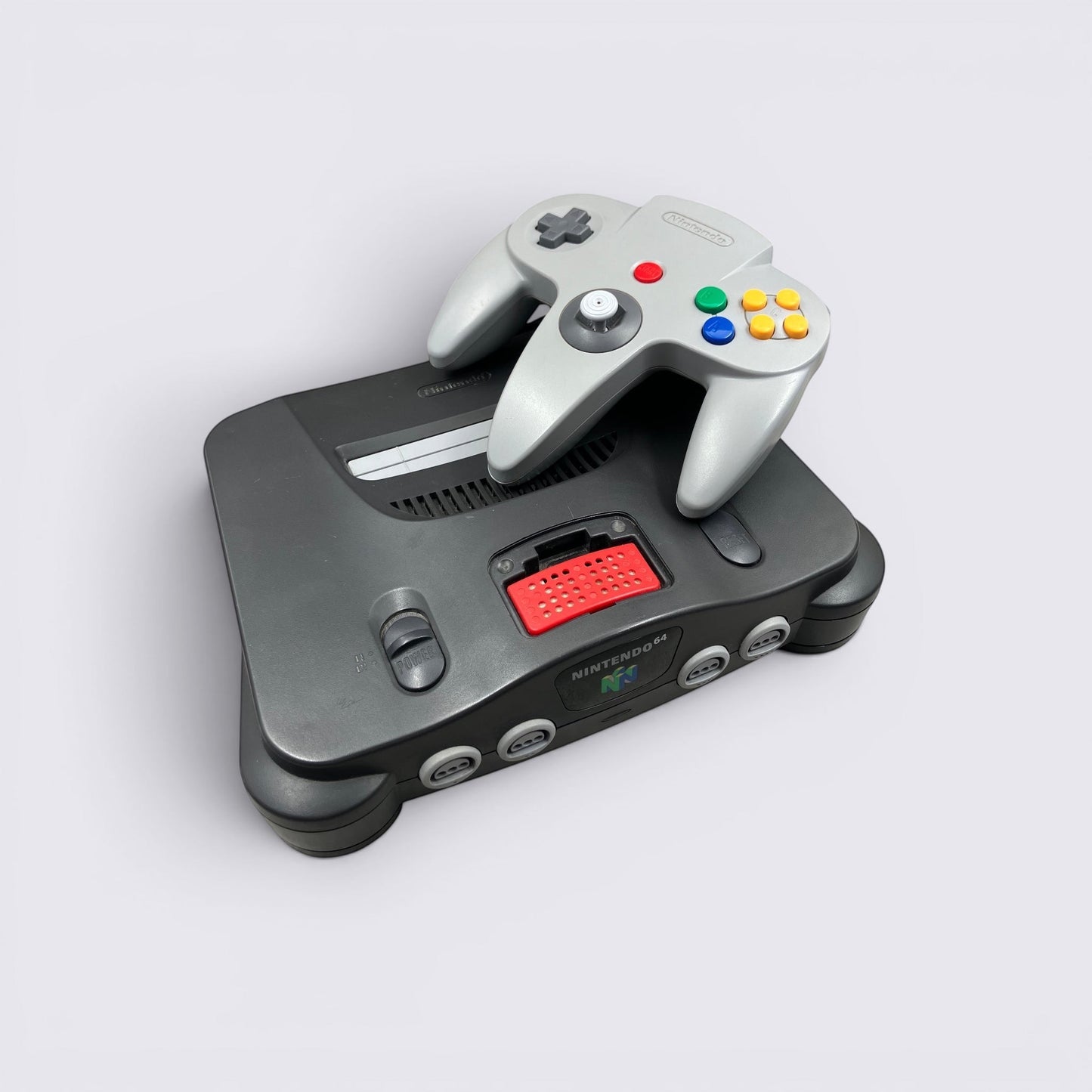 MrPixel black Nintendo 64 console with a grey controller on a light background