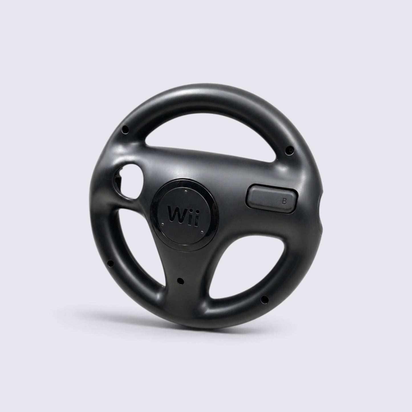 MrPixel black Nintendo Wii Wheel steering accessory for motion-controlled racing games on a light grey background.