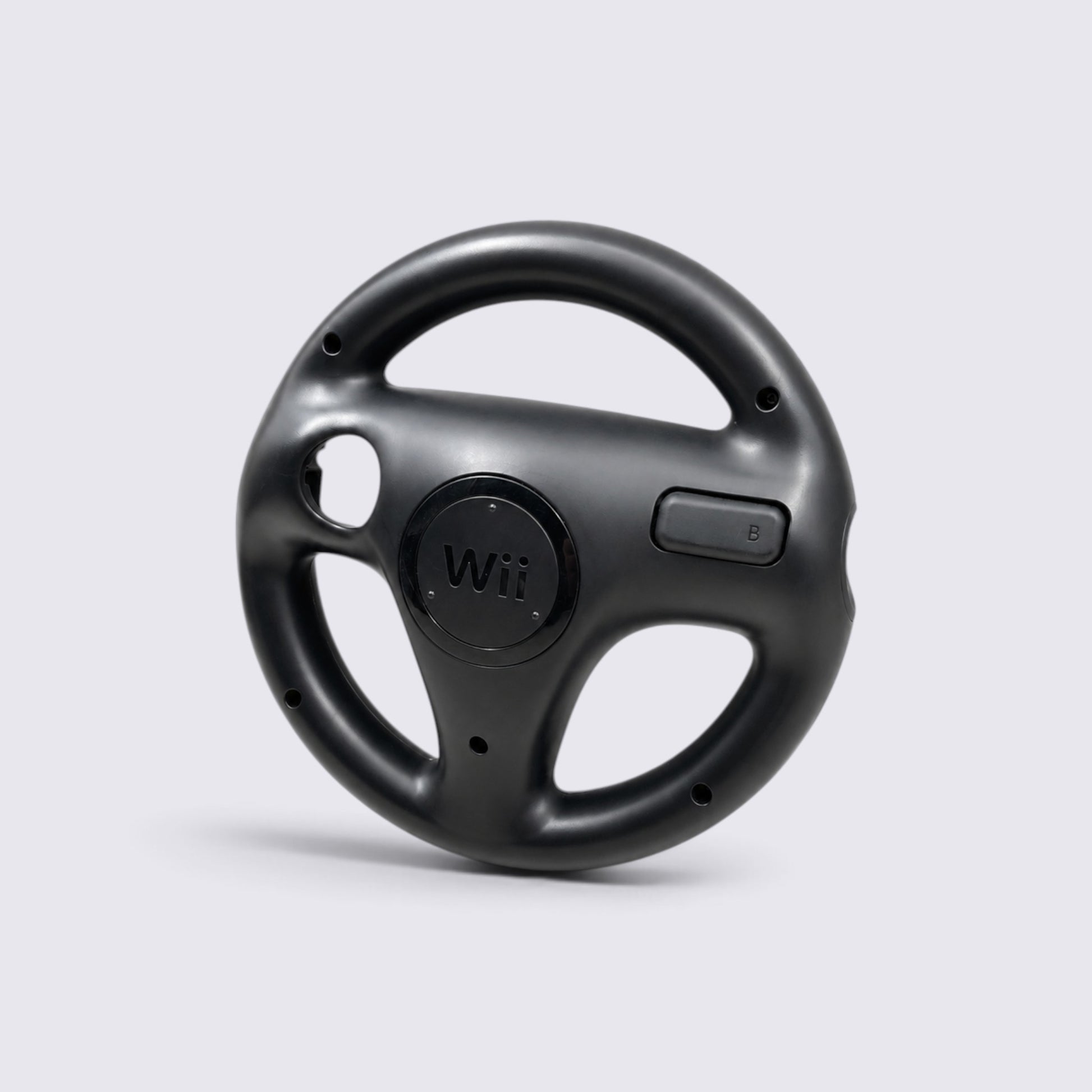 MrPixel black Nintendo Wii Wheel steering accessory for motion-controlled racing games on a light grey background.