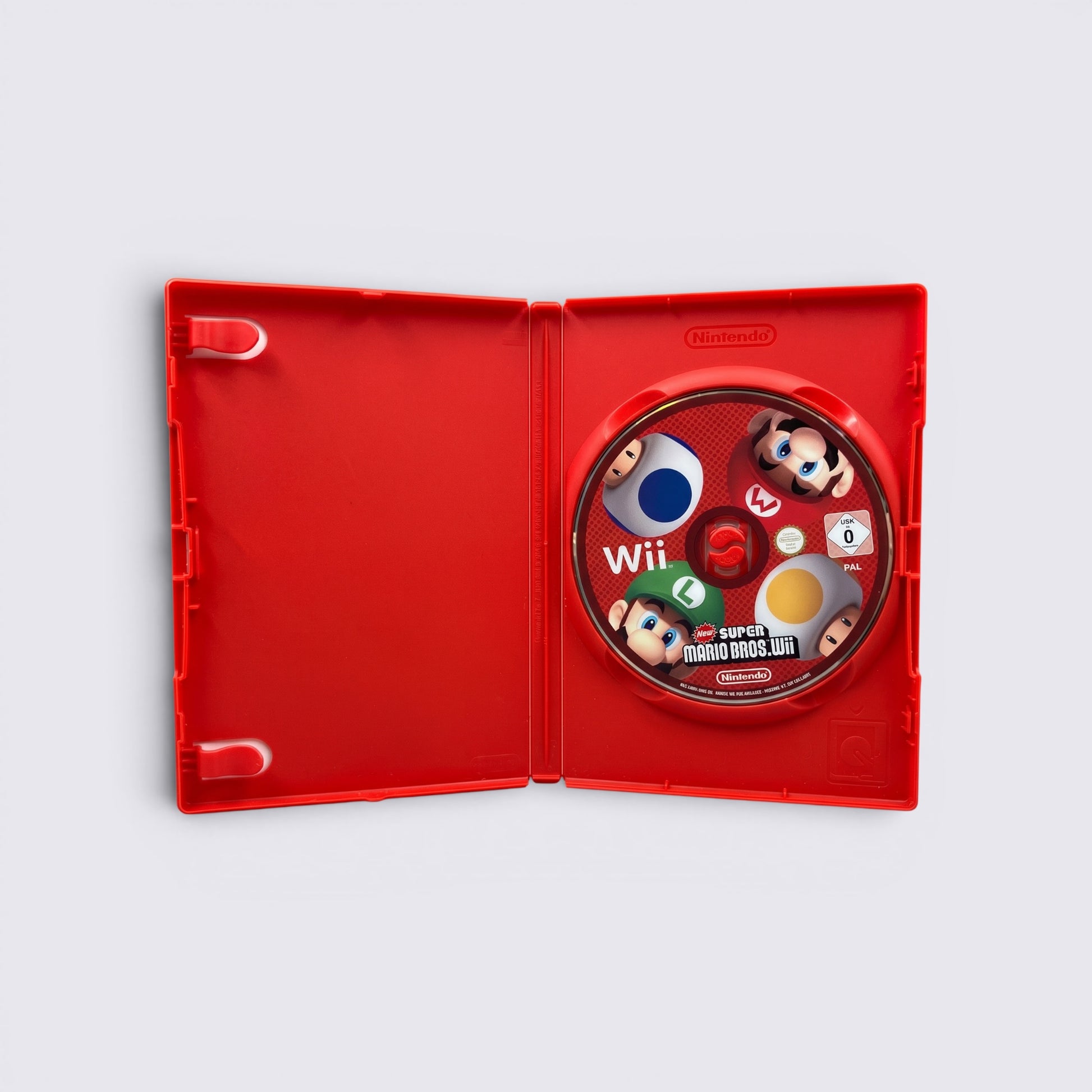 MrPixel New Super Mario Bros. Wii game disc inside a red plastic case featuring Mario, Luigi, and Toad characters.
