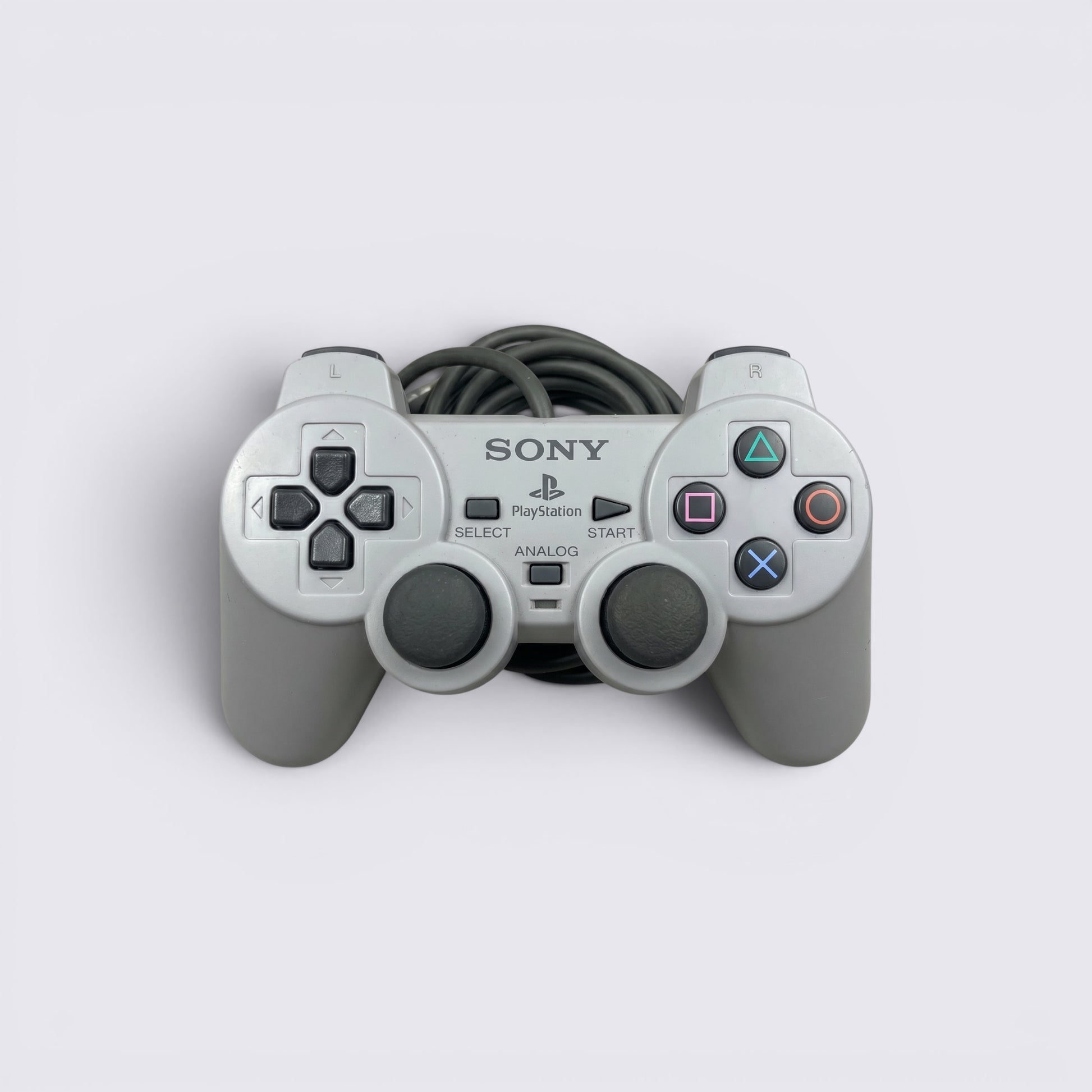 MrPixel grey Sony PlayStation 1 analog controller with dual sticks, face buttons, and wired connection.