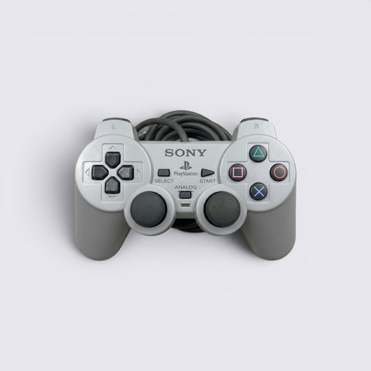 MrPixel grey Sony PlayStation 1 analog controller with dual sticks, face buttons, and wired connection.