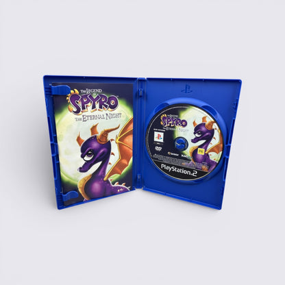 MrPixel The Legend of Spyro The Eternal Night PlayStation 2 game case with disc and manual open on a grey surface.