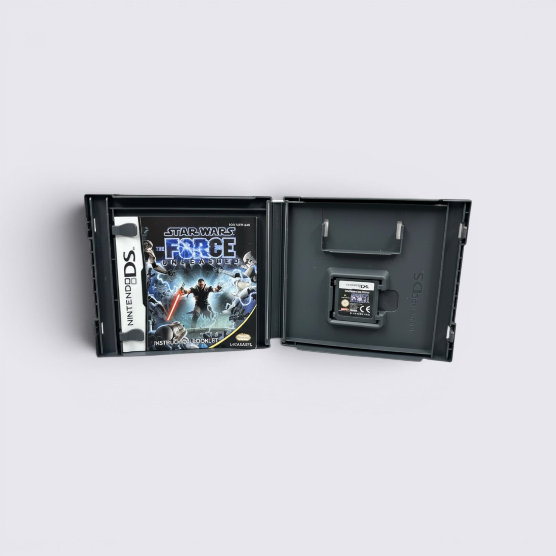 MrPixel Star Wars The Force Unleashed Nintendo DS game case with cartridge and manual open on a grey surface