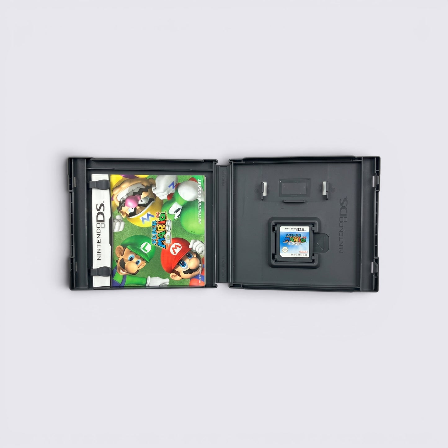 MrPixel Super Mario 64 DS game case open with instruction booklet and game cartridge on a grey surface